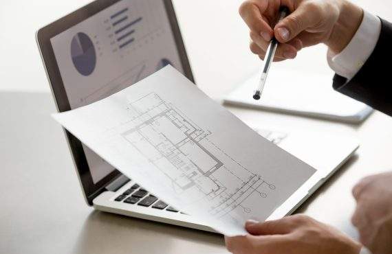 male hand holding project plan statistics on screen close up scaled
