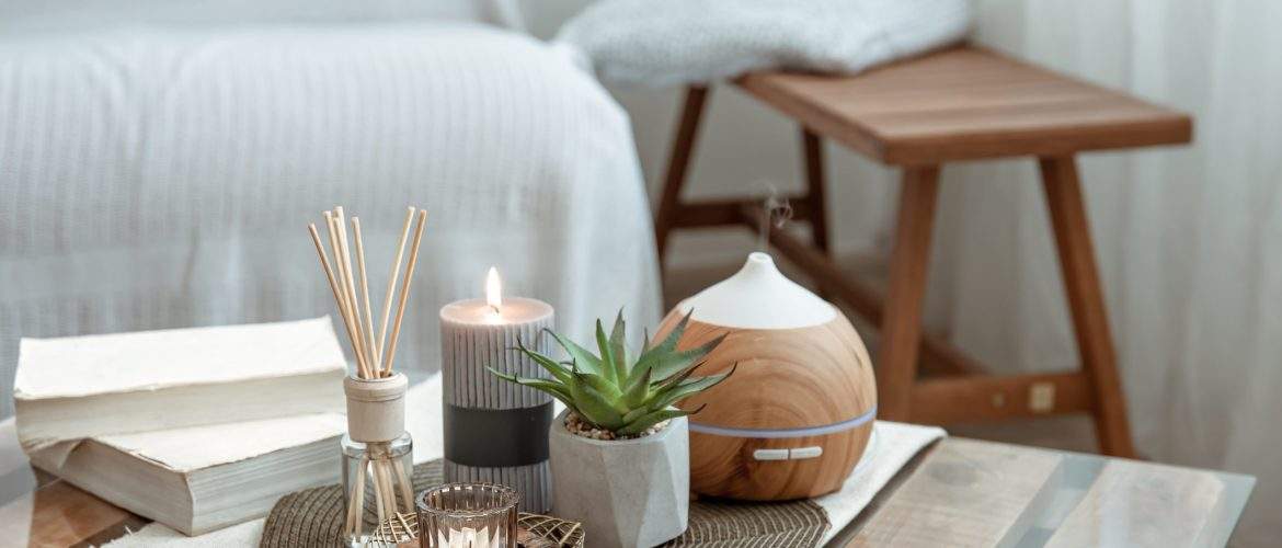 composition with incense sticks diffuser candles and books on the table in the interior of the room scaled