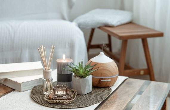 composition with incense sticks diffuser candles and books on the table in the interior of the room scaled